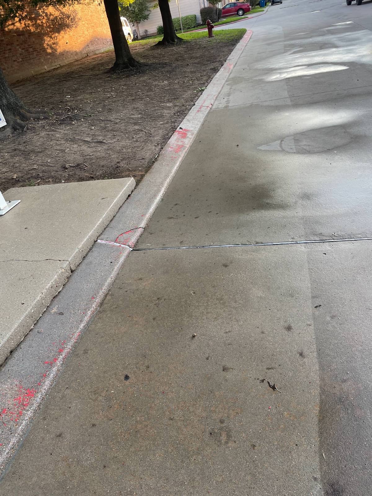 Clean concrete surface after commercial pressure washing at the Houston HOA entrance