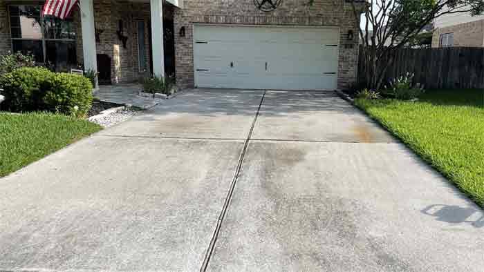 Driveway before pressure washing showing heavy dirt and tree sap buildup