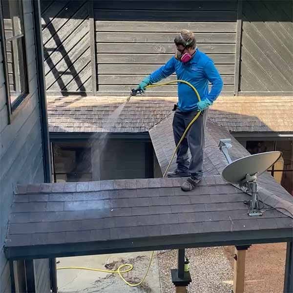 Low-pressure soft washing being applied to a home's siding instead of a high-pressure blast
